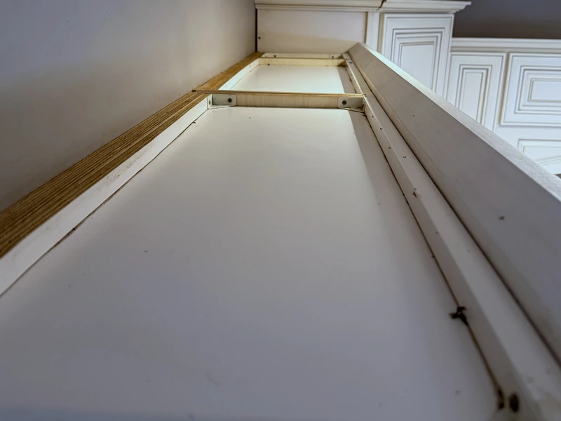 The same cabinet top after a move-out clean, wiped clear of dust and grime